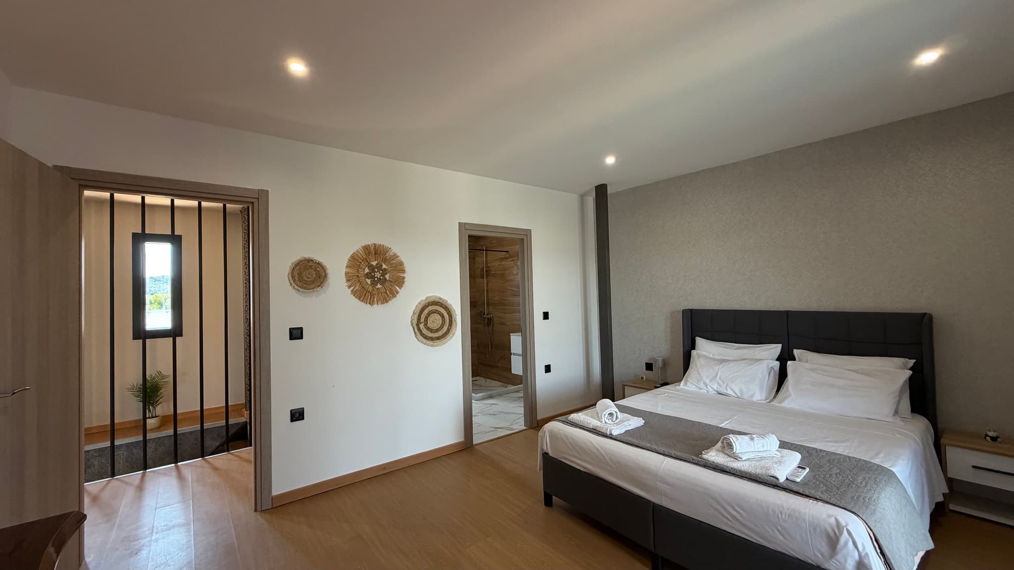 Elegant bedroom with natural light and a glimpse of the sea beyond