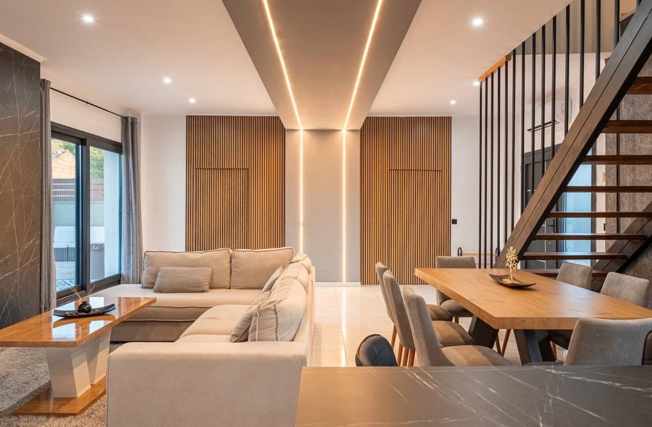 Elegant dining and living space with wood slat walls and sculptural lighting